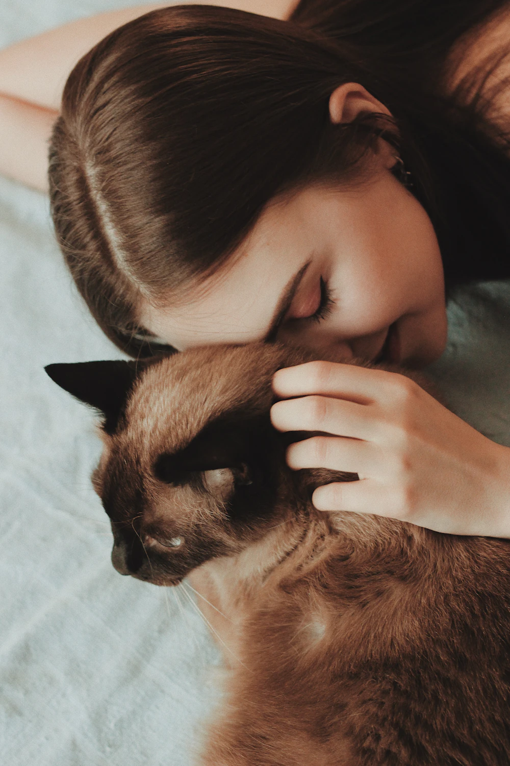 A woman cuddling her cat at home